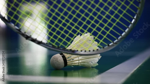 badminton racket scooping shuttlecock from court ground