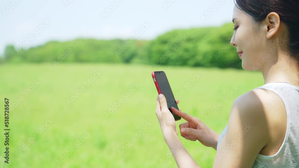 屋外でスマートフォンを使う女性