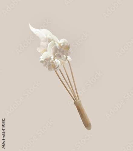 Whipped cream at flying wooden whisker at pale beige background. Levitation food concept with baking utensils. Front view.