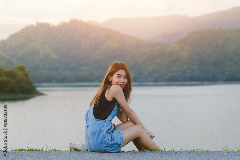 portrait of beautiful Asian woman looking at camera with scenery mountain and lake view as background