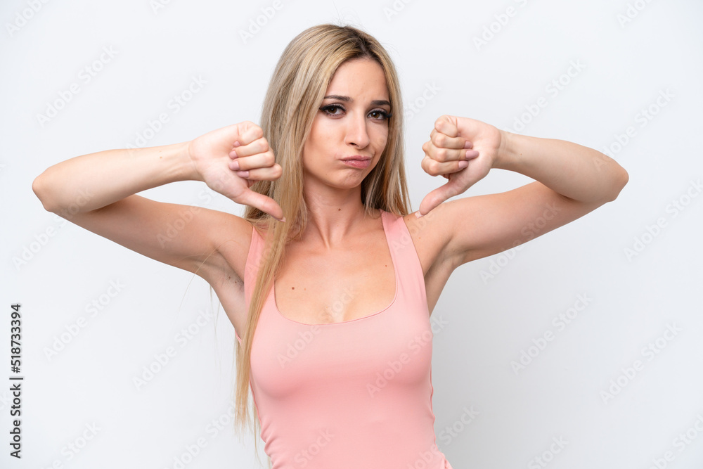 Pretty blonde woman isolated on white background showing thumb down with two hands Pretty blonde woman isolated on white background showing thumb down with two hands