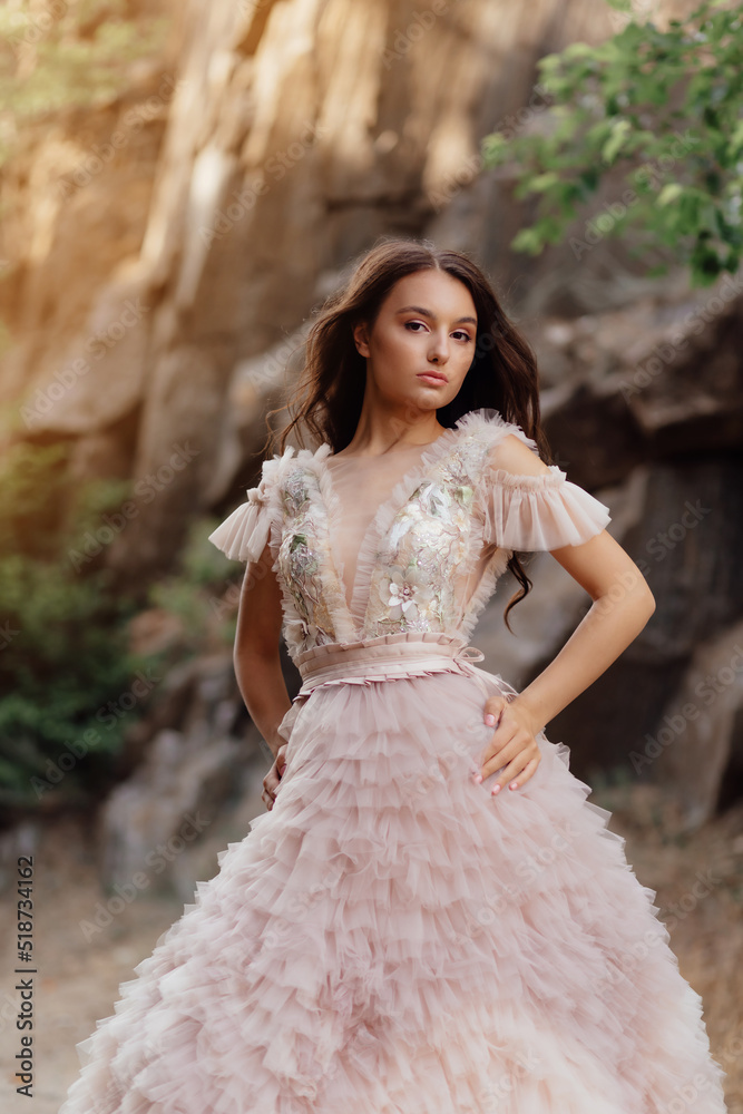 Fashionable young model in boho style dress on a background of rocks. Female beauty and style concept. Fashionable young model in boho style dress on a background of rocks. Female beauty and style concept.