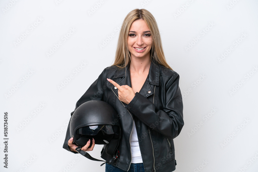 Pretty blonde woman with a motorcycle helmet isolated on white background pointing to the side to present a product Pretty blonde woman with a motorcycle helmet isolated on white background pointing to the side to present a product