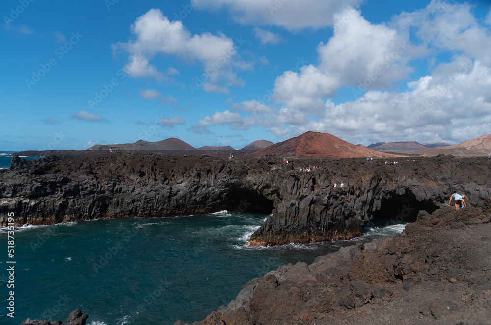 Impresionante vista de los acantilados de la costa de las islas canarias de Lanzarote con rocas negras y un hermoso mar. Los hervideros en Lanzarote Islas Canarias con un paisaje volcánico al fondo.
