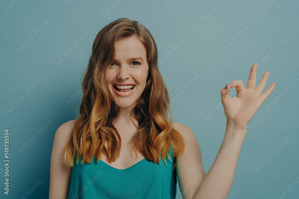 Happy young charming woman with showing ok sign with fingers and smiling at camera Happy young charming woman with showing ok sign with fingers and smiling at camera