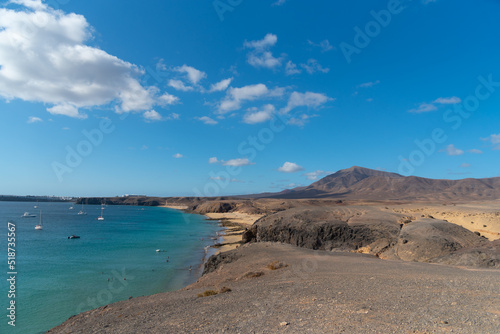 Fototapeta Naklejka Na Ścianę i Meble -  Vista aérea de la playa de la cera, en Lanzarote. Islas Canarias. cielo azul sobre una cala en verano. paisaje árido y volcán de fondo. 