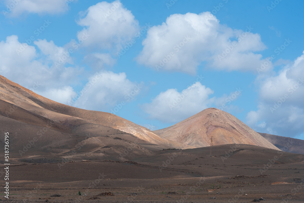 Vista panorámica del Parque Nacional de Timanfaya, un paisaje volcánico y desértico con grandes montañas durante un día soleado con el cielo azul despejado en Lanzarote Islas Canarias.