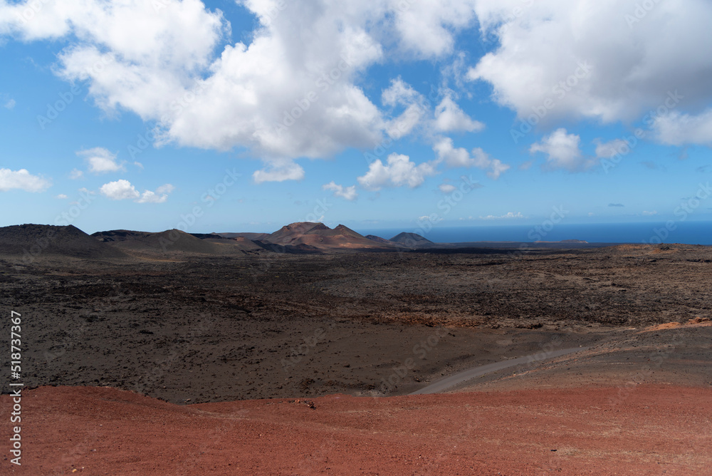 Vista panorámica de un paisaje desértico y volcánico en el Parque natural de Timanfaya durante un día soleado con el cielo azul despejado en Lanzarote Islas Canarias.