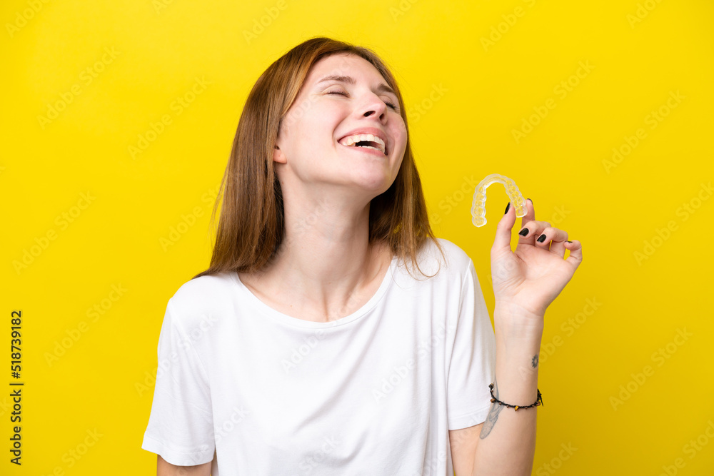 Young English woman holding invisible braces laughing Young English woman holding invisible braces laughing