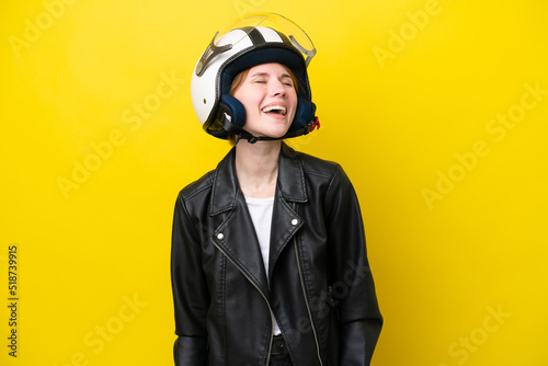 Young English woman with a motorcycle helmet isolated on yellow background laughing © luismolinero