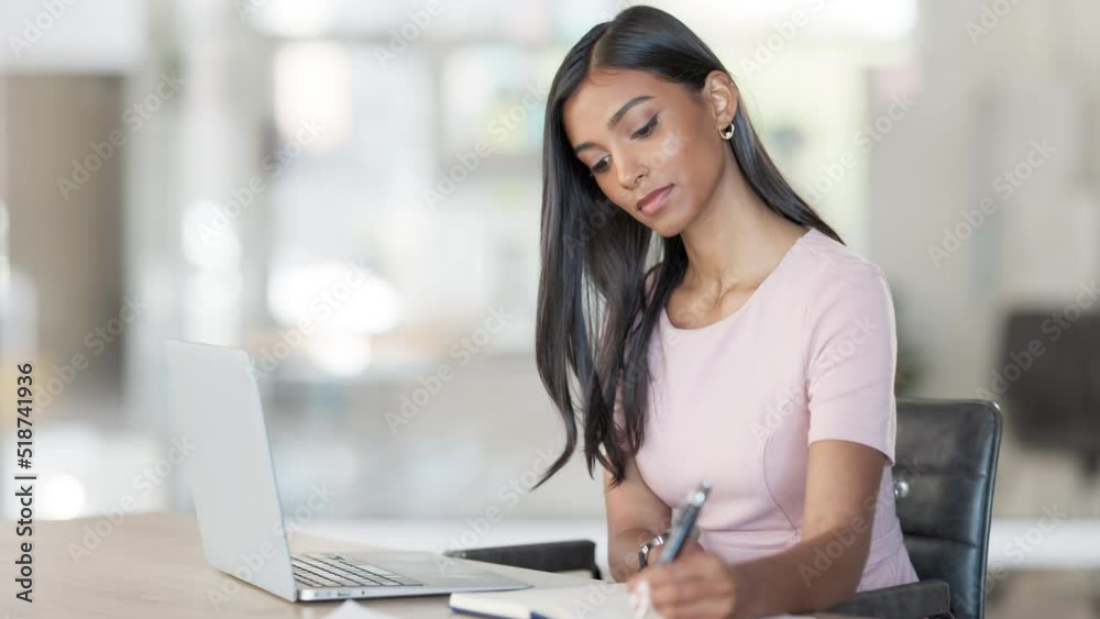 Young business woman using a laptop to work online and taking notes in her diary in an office at work. Female corporate professional typing, sending emails and checking things off her to do list