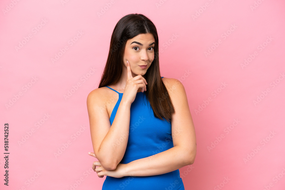 Young Brazilian woman isolated on pink background and thinking Young Brazilian woman isolated on pink background and thinking