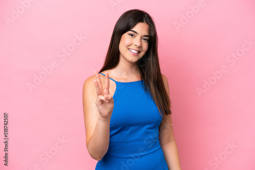 Young Brazilian woman isolated on pink background happy and counting three with fingers