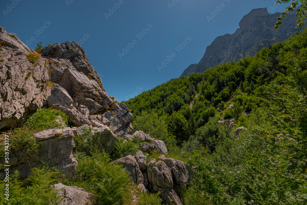 Rock and mountains around popular tourist attraction in Valbona valley, Albania, a Mulliri i Vjeter old mill house. Bridge leading to the mill in poor condition.