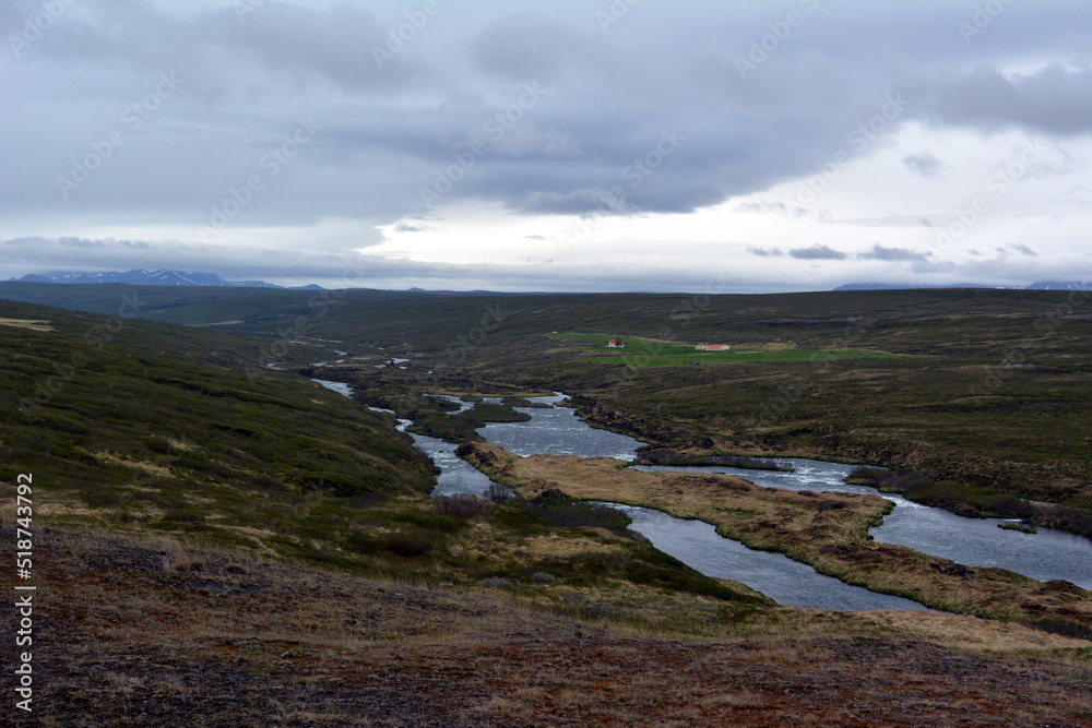 Lava field in Iceland Godafoss Falls area on the background of distant mountains and stormy sky