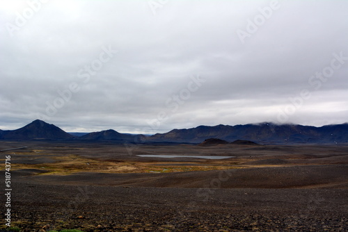Lava field in Iceland Dettifoss Falls area on the background of distant mountains and stormy sky. © lana