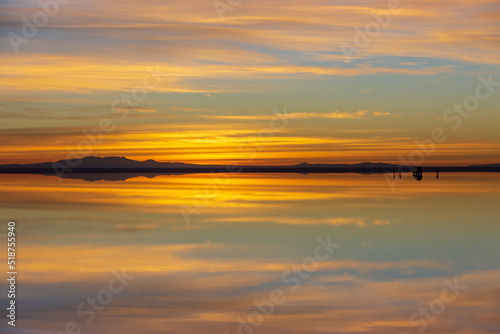 Sun rise over the Salt Flats of Uyuni (Salar de Uyuni) and a mirror reflection of the landscape. It is the world's largest salt flat, found in Bolivia.