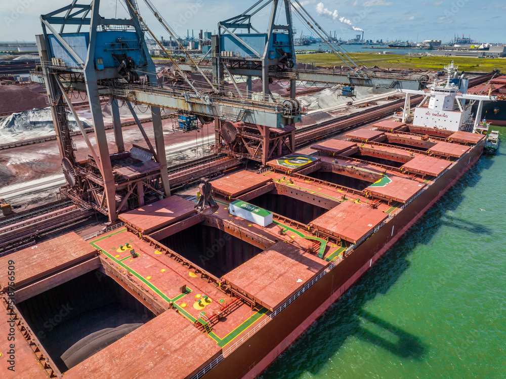 Naklejka premium Bulk Carrier Ship Offloading Cargo By Crane for Processing