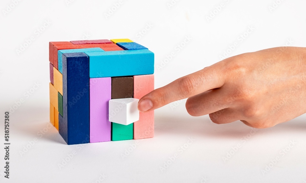 Woman arranging puzzle cube by putting missing element. Construction last stage, decision making process. Kids or family toy for intelligence, logical thinking, creativity development. photo Woman arranging puzzle cube by putting missing element. Construction last stage, decision making process. Kids or family toy for intelligence, logical thinking, creativity development. photo