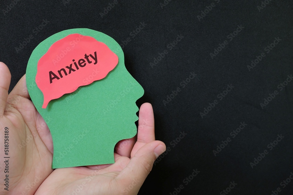 Anxiety disorder patient help, care, recovery, therapy and treatment concept. Hand holding human head profile with word text on brain.