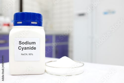 Selective focus of a bottle of Sodium Cyanide pure chemical compound used for cyanide fishing. White laboratory background.	 photo