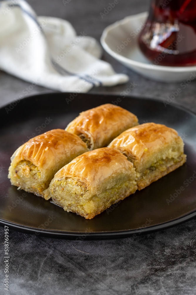 Turkish baklava. Baklava slices with pistachio on a dark background. Bakery products. Vertical view. Turkish cuisine. Close-up.