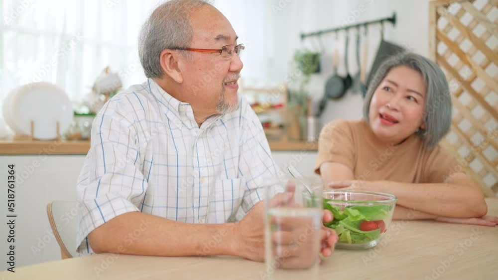 Happy senior adult couple sitting in the kitchen room. Elderly man talking with elder woman and smile. Lover, wellness and retirement. Family love and support together. Healthcare and lifestyle