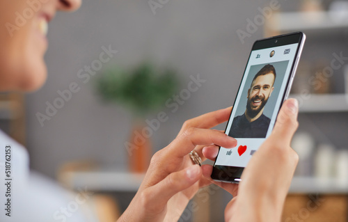Obraz na plátně Smiling woman giving like to photo on social media or swiping on online dating app