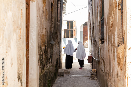 African girls in traditional clothes on the narrow street of Stone Town. Zanzibar © Nataliya
