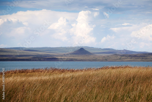 A lake and mountain with a blue sky and a white cloud. Natural landscape background.