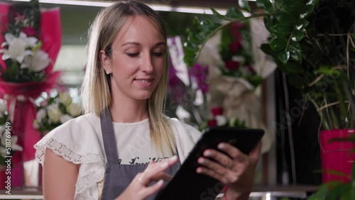 Close up of a young girl using a tablet while working in a flower shop