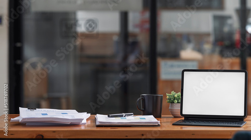 Creative workspace, home office. Mockup blank screen portable tablet with magic keyboard and paperwork on wooden table.