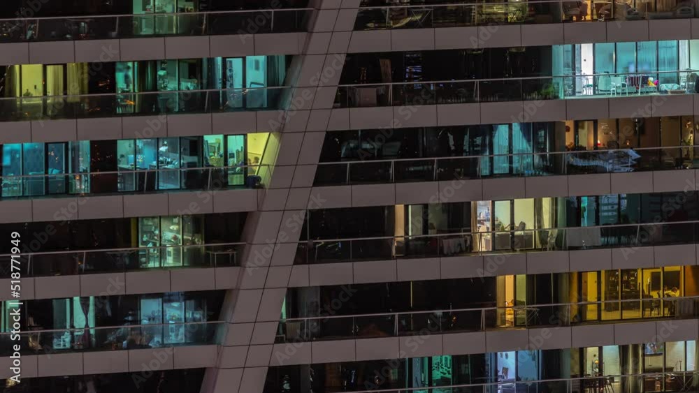 Night view of many glowing windows in apartment residential tower timelapse. High rise skyscraper with lights and motion in rooms Night view of many glowing windows in apartment residential tower timelapse. High rise skyscraper with lights and motion in rooms
