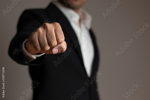 Business manager with clenched fist on dark background. Angry businessman. Stick out the fist.