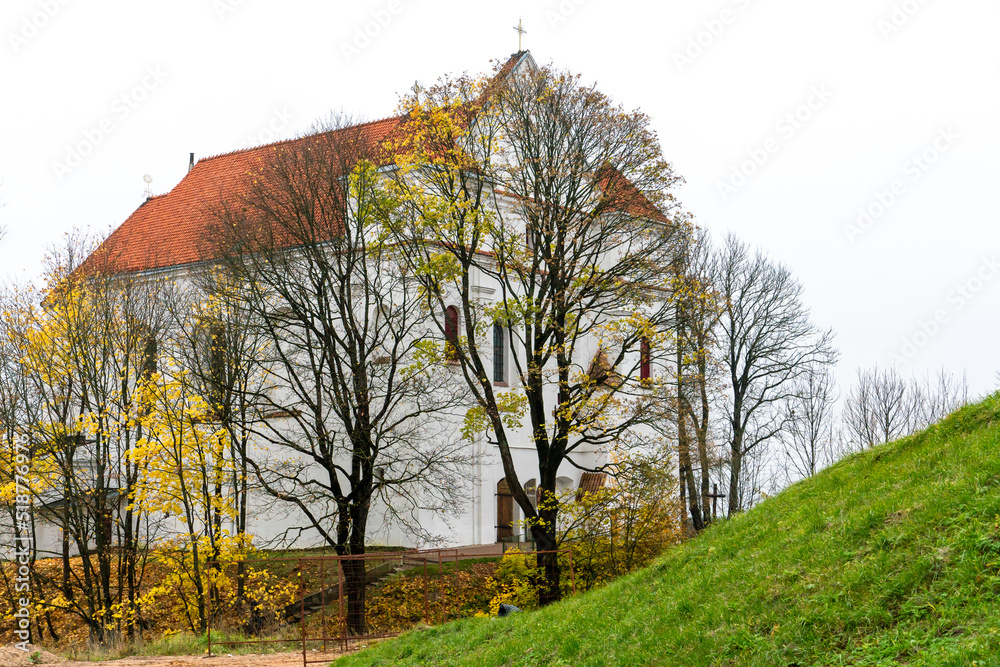 Church of the Transfiguration of the Lord in Novogrudok autumn. A beautiful Catholic cathedral showered with fallen leaves and autumn colors.