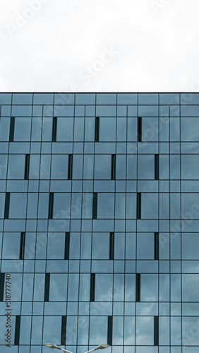 High-rise modern building made of blue glass. An unusual glass skyscraper. The concept of building modern buildings with futuristic design for business and a happy life.