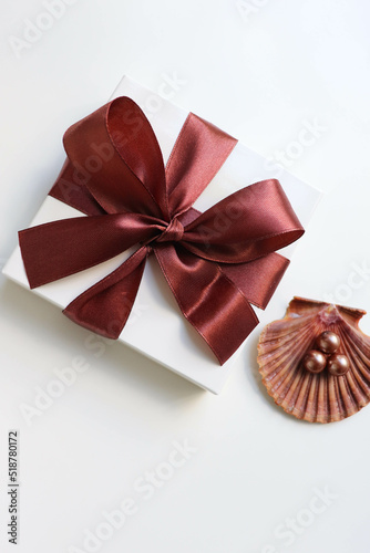 gift concept. gift box with brown bow and jewelry isolated on white background. women's accessories