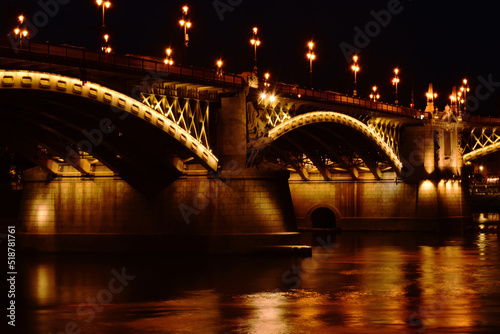 Fototapeta Naklejka Na Ścianę i Meble -  the Margaret bridge in Budapest. perspective night view. bright, illuminated steel arches. reflection on the water. tourism and travel concept. transportation and structural design. evening photo. 