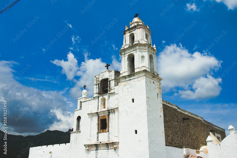 Fototapeta premium Iglesia blanca con cielo azul y nubes