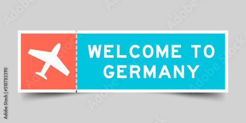 Orange and blue color ticket with plane icon and word welcome to germany on gray background