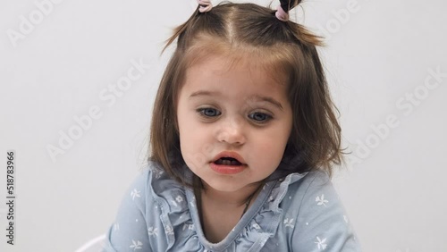 Close-up face of a cute attractive little girl with big eyes. In room. White background.