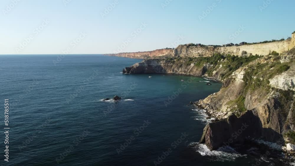 Aerial panoramic view of seascape with crystal clear azure sea and rocky shores. Yachts in a beautiful lagoon on backdrop of rocks. The concept of an ideal destination for summer travel and vacation. Aerial panoramic view of seascape with crystal clear azure sea and rocky shores. Yachts in a beautiful lagoon on backdrop of rocks. The concept of an ideal destination for summer travel and vacation.