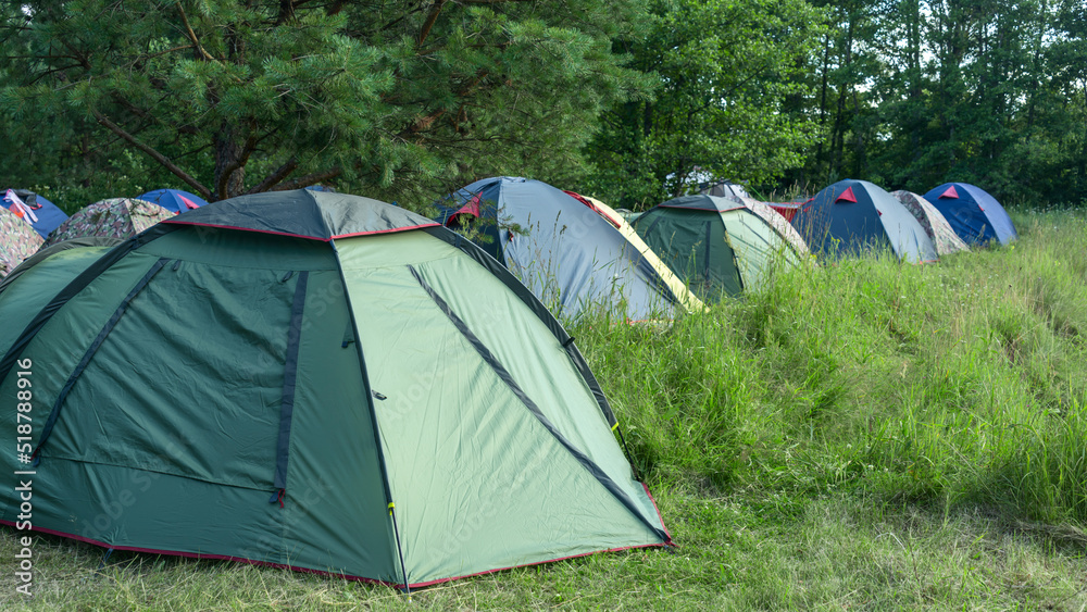Tents camping area. Camping and tent. Tourist tents stands under the tree. Travel and adventure concepts.
