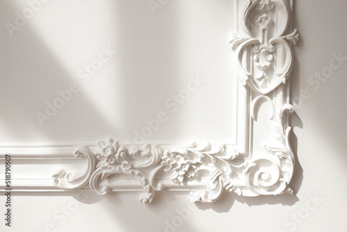 Decorative clay stucco relief molding with ornaments on white ceiling in abstract classical style interior