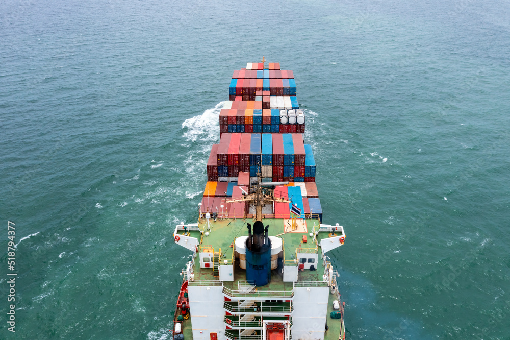 Fototapeta premium aerial back view of container ship carrying cargo container import export internatioonal and worldwide, business and industry goods logistic transportation by container ship in open sea,