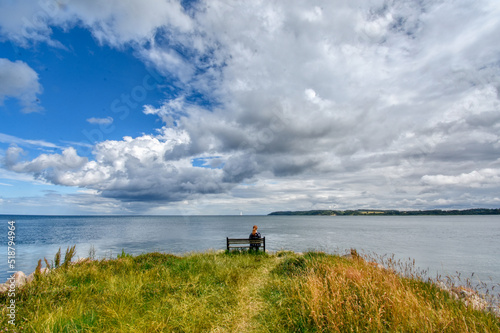 Woman on bench viewing seascape in Fredericia