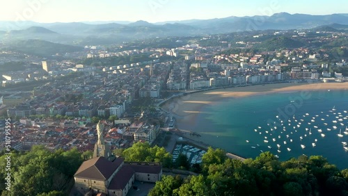 Unique cinematic perspective of the European city SAN SEBASTIAN. Situated in Spain -Vesque Country is a famous travel destination. Drone rotating around the Statue of Jesus. Panoramic view of the city