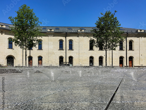 Street fountains made of marble tiles in a city square on the background of a building in a short exposure