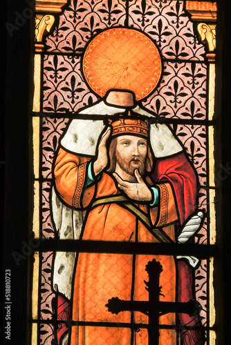 Ploumilliau (Plouilio), France. Stained glass window depicting Saint Milliau of Cornwall holding his beheaded or decapitated head inside the church photo