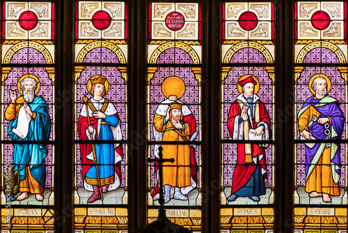 Ploumilliau (Plouilio), France. Stained glass window in St Miliau Church depicting saints John, Melor, Milliau, Ivo and Peter photo